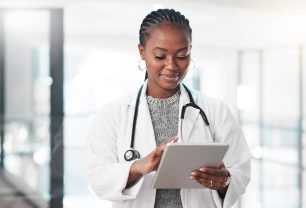A female black doctor looking through an tablet.